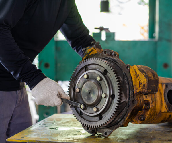 Professional mechanic man inspection hydraulic gear pump of wheel loader in workshop, repair maintenance heavy machinery Professional mechanic man inspection hydraulic gear pump of wheel loader in workshop, repair maintenance heavy machinery