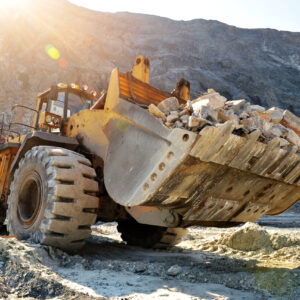Wheel loader machine unloading rocks in the open-mine of iron ore
