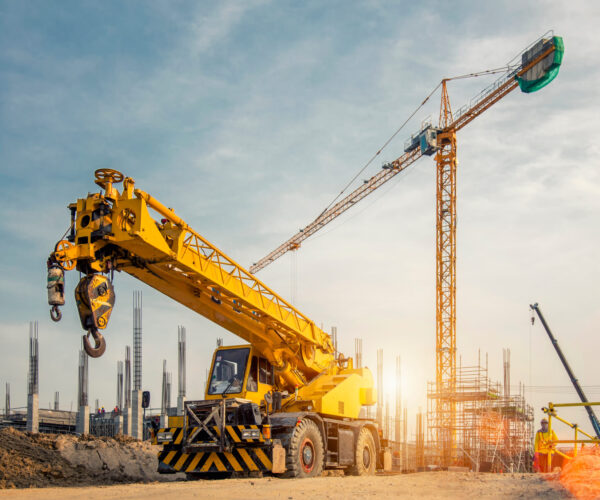 Mobile Crane on a road and tower crane in construction site Mobile Crane on a road and tower crane in construction site