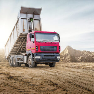Large mining dump truck at the construction site. Powerful modern equipment for the delivery and transportation of bulk cargo. Construction site. Rental of construction equipment